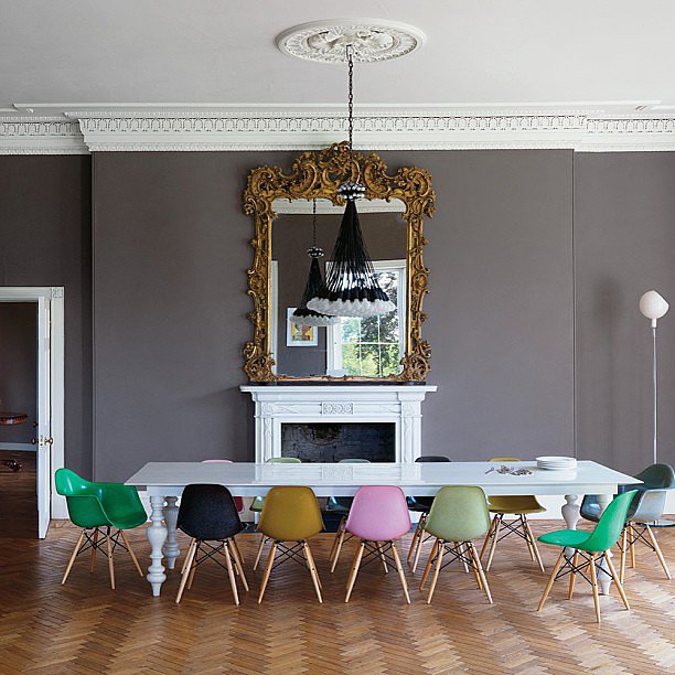 long-dining-table-surrounded-colorful-Eames-chairs-occupies